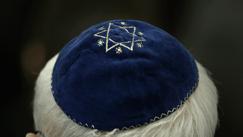 Ein Mann trägt in der Synagoge in Mainz (Rheinland-Pfalz) eine Kippa mit einem aufgenähtem Stern. Ein Mann trägt in der Synagoge in Mainz (Rheinland-Pfalz) eine Kippa mit einem aufgenähtem Stern.