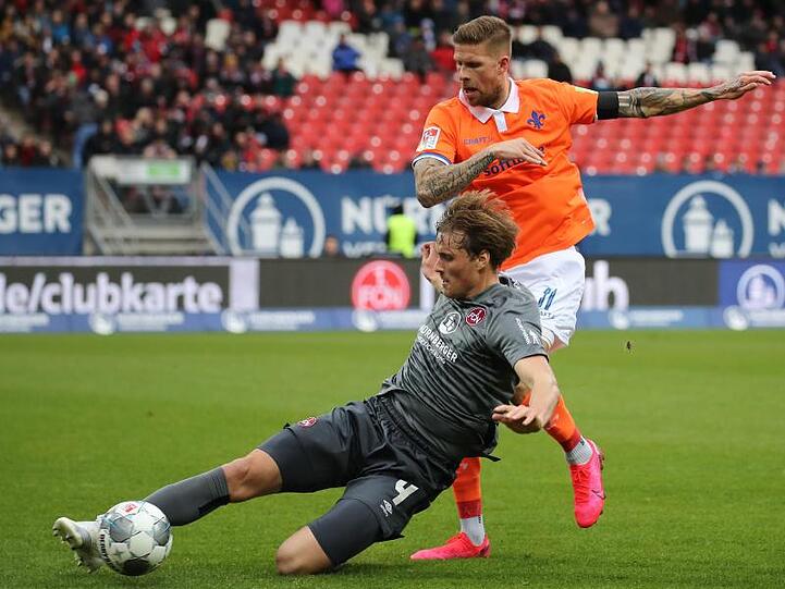 Der Nürnberger Asger Sörensen (l) kämpft mit dem Darmstädter Tobias Kempe um den Ball. Foto: Daniel Karmann/dpa