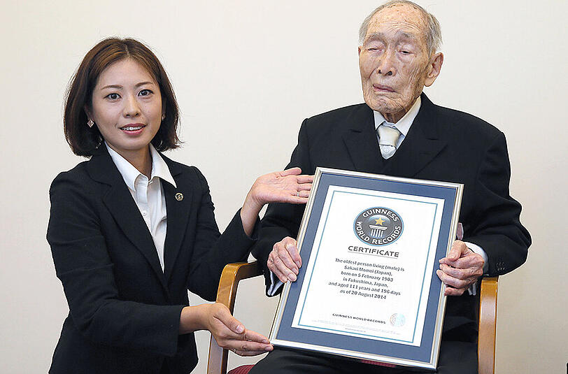Sakari Momoi bekommt im August 2014 in Tokio eine Urkunde als ältester Mann vom Guinness Buch der Rekorde.
