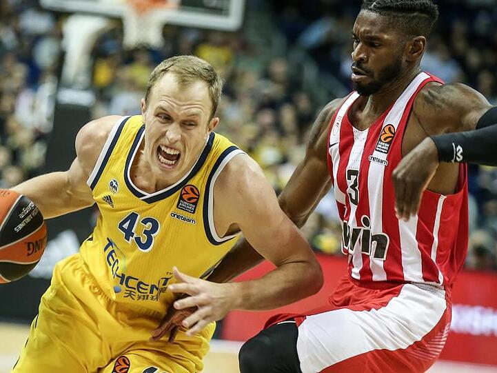 Albas Luke Sikma (l) kämpft sich durch die Abwehr von Olympiakos Piräus.