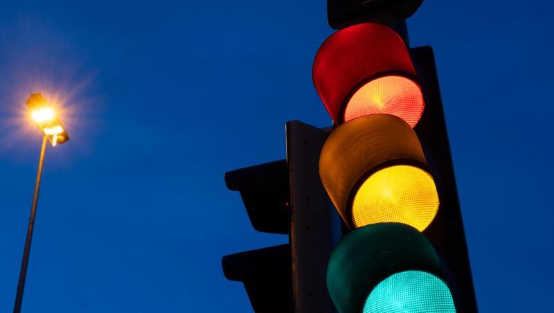 Eine Ampel zeigt am frühen Morgen die Farben rot, gelb und grün.
