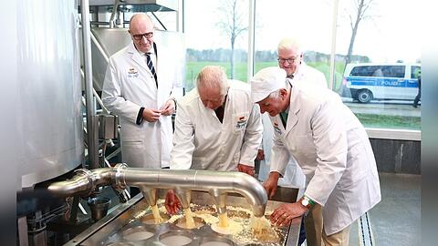König Charles III. (2.v.l.) und Bundespräsident Frank-Walter Steinmeier (hinten) machen Käse in einem Ökodorf.