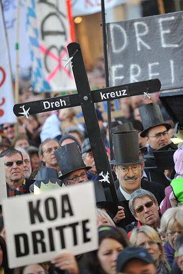 Teilnehmer einer Demonstration gegen den Bau der dritten Startbahn am Münchner Flughafen halten am Samstag auf dem Marienplatz in München Plakate in die Höhe.