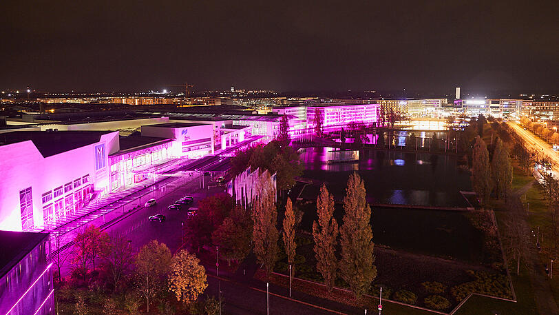 Das Gebäude der Messe München - auch in pinkes Licht gehüllt.