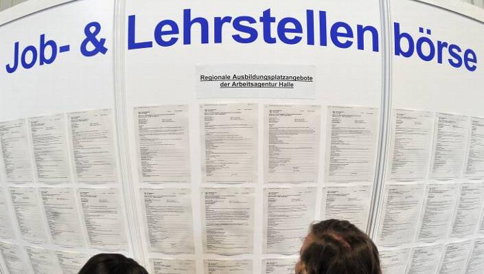 Zwei Jugendliche stehen in Halle vor einer Wand mit Job- und Lehrstellenangeboten. Zwei Jugendliche stehen in Halle vor einer Wand mit Job- und Lehrstellenangeboten.