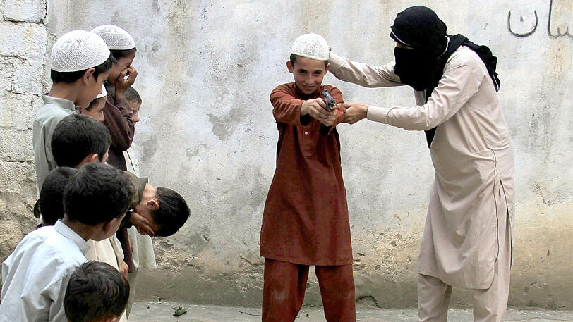 Ein nicht identifizertes IS-Mitglied (r) zeigt am 30.07.2015 Kindern anderer Kämpfer den Umgang mit einer Pistole an einem nicht genannten Ort in der Kunar-Provinz in Afghanistan.