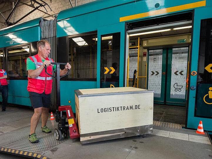 Auf dem VGF Betriebshof Gutleut wird Ware mit einem Hubwagen in eine Tram geschoben.