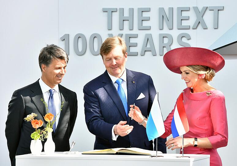 An der Seite vom BMW-Vorstandsvorsitzenden Harald Krüger tragen sich die niederländischen Royals ins Gästebuch der BMW-Welt ein.