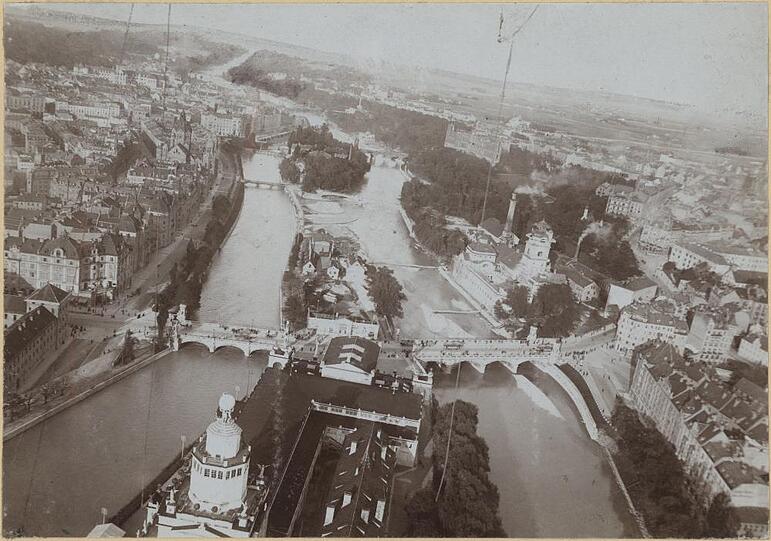 1899: Blick von oben auf die Ludwigsbrücke. Und, nein, das Gebäude im Vordergrund ist nicht das Deutsche Museum (das wird erst 1906 bis 1925 erbaut). Es ist der Ausstellungsbau für die "II. Kraft- und Arbeitsmaschinenausstellung München" im Jahre 1898.