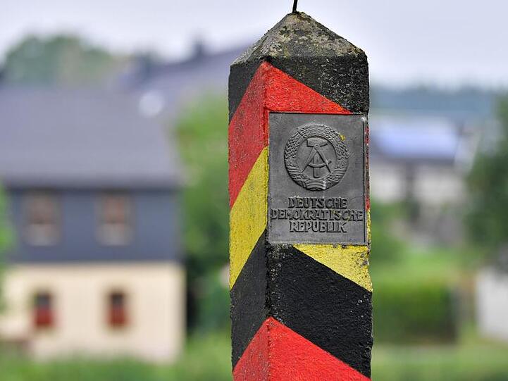 Ein Grenzpfahl mit dem Wappen und dem Schriftzug "Deutsche Demokratische Republik". Foto: Martin Schutt/Archivbild