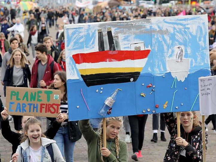 Teilnehmer einer Demonstration von Fridays for Future halten Transparente in die Höhe. Foto: Bernd Wüstneck/zb/dpa/Symbolbild