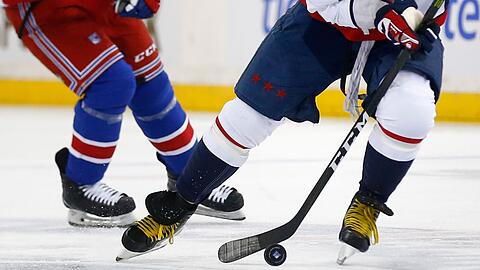 Zwei Eishockeyspieler kämpfen um den Puck.
