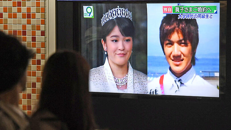 Passanten schauen in Tokio auf einen TV-Bildschirm einen Bericht zur Verlobung der japanischen Prinzessin Mako.