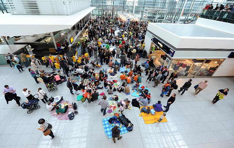 Gegen Fluglärm demonstrierende Demonstranten picknicken am Samstag (24.03.12) am Flughafen Franz-Josef-Strauss in einem Teil der Abflughalle des Terminal 2.