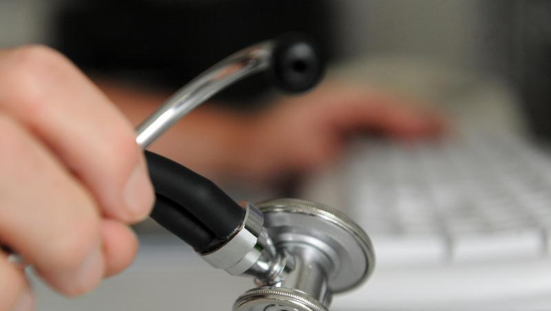 Eine Person hält ein Stethoskop in der rechten Hand. Die linke Hand bedient eine Computertastatur. Foto: Marijan Murat/Archiv Eine Person hält ein Stethoskop in der rechten Hand. Die linke Hand bedient eine Computertastatur. Foto: Marijan Murat/Archiv