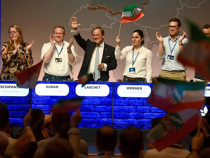 Nordrhein-Westfalens Regierungschef Armin Laschet winkt beim Deutschlandtag der Jungen Union vom Podium. Neben ihm steht der JU-Bundesvorsitzende Tilman Kuban.