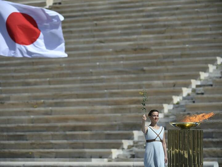 Bei einer kleinen Feier wird das olympische Feuer an die Organisatoren der Sommerspiele von Tokio 2020 übergebe.
