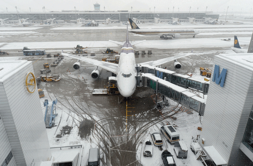 Ein Flugzeug steht auf dem schneebedeckten Flughafen in München (Bayern).