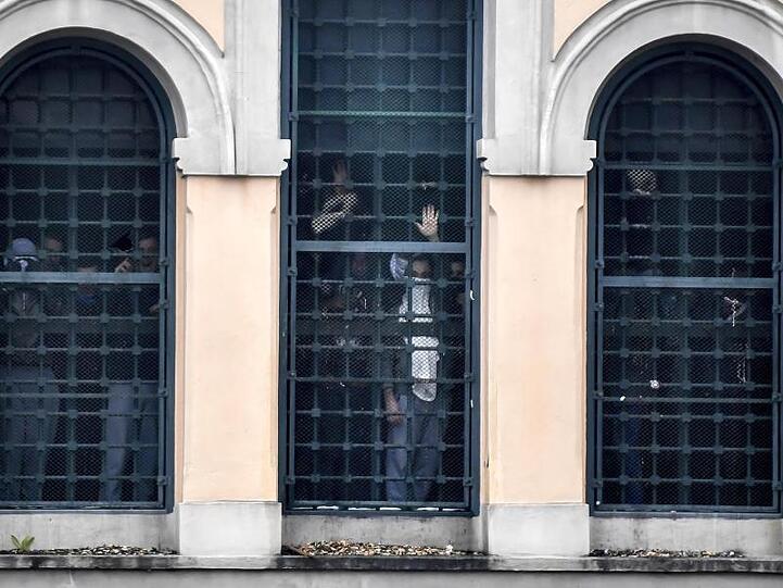 Rebellierende Menschen hinter den Fenstern des San-Vittore-Gefängnisses.