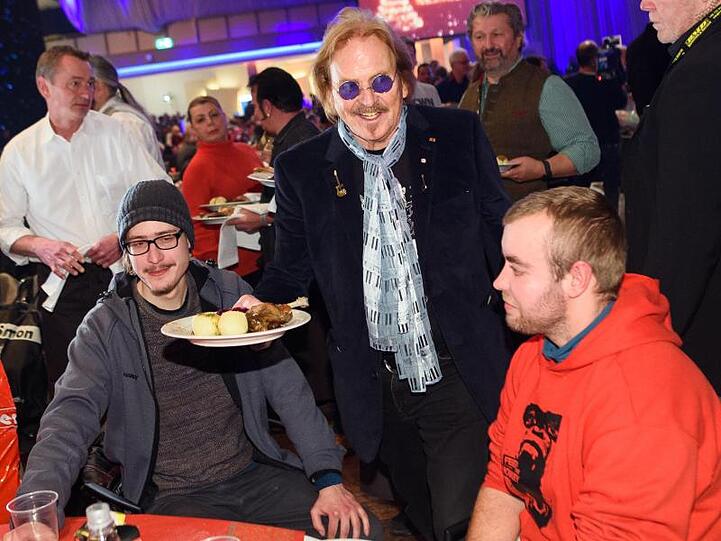 Musiker Frank Zander (M) verteilt bei seinem 25. Weihnachtsfest für Obdachlose und Bedürftige Weihnachtsgans an die Gäste.
