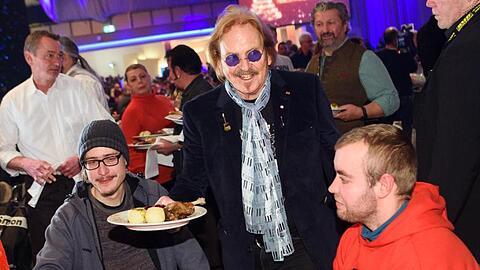 Musiker Frank Zander (M) verteilt bei seinem 25. Weihnachtsfest für Obdachlose und Bedürftige Weihnachtsgans an die Gäste.
