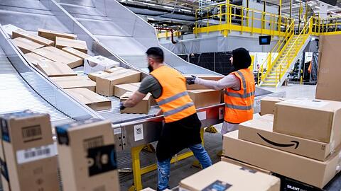 Mitarbeiter des Paketversenders Amazon sortieren Pakete im Sortierzentrum in Garbsen.