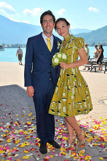 Das Brautpaar David Dietl und Lydie Leschak vor dem Tegernsee mit den Alpen im Hintergrund.