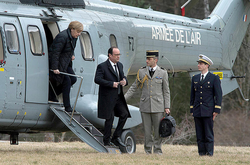 Der französische Präsident Francois Hollande (2.v.l.) und die deutsche Bundeskanzlerin Angela Merkel (l, CDU) steigen in Seyne Les Alpes, Frankreich aus dem Hubschrauber.