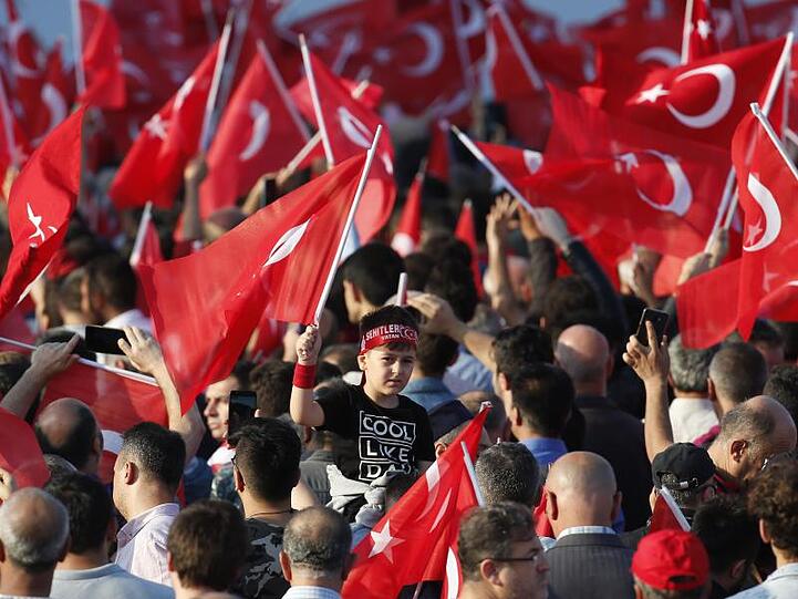Menschen versammeln sich in Istanbul mit Türkei-Fahnen zu einer Veranstaltung am Jahrestag des gescheiterten Putschversuchs.