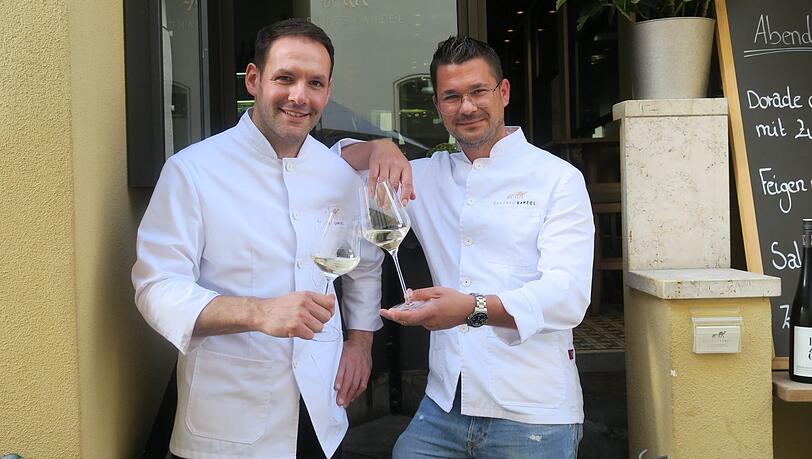 Prost  - auf ihr Weinbar-Bistro Kleines Kameel: Das neue Wirte-Duo Georg Weber (l.) und Stefan Aumaier stößt im Hofgraben miteinander an.
