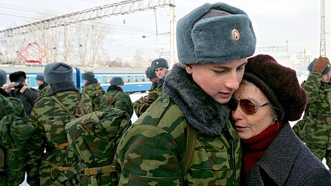 Ein junger Rekrut, der zum Militärdienst einberufen worden ist, umarmt vor der Abreise in die westsibirische Stadt Kemerowo seine Mutter.