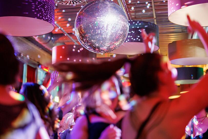Publikum tanzt in Disco. Symbolbild