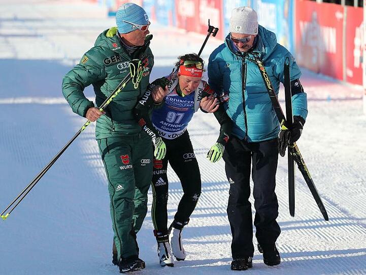 Stark am Rande ihrer Kräfte ist Laura Dahlmeier beim Sprint als Vierte ins Ziel gelaufen. Helfer müssen sie nach dem Rennen stützen.