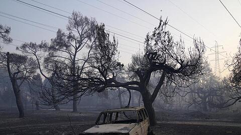 Ein verbranntes Auto nach einem Waldbrand in der Region Varibobi im Norden Athens.