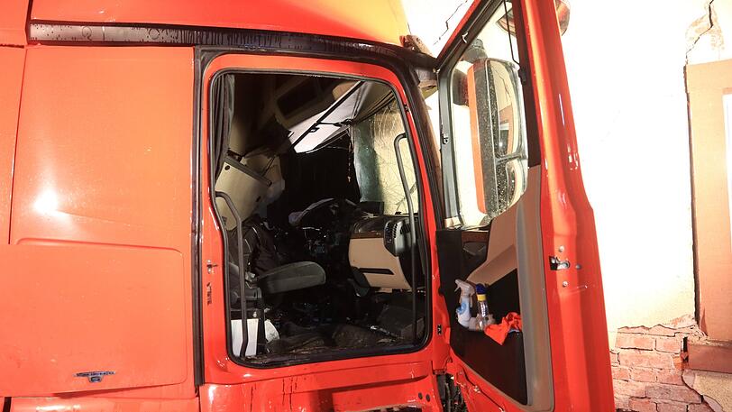 Der Sattelzug rammte ein geparktes Auto und donnerte gegen ein Haus. Die Rettung des Fahrers gestaltete sich extrem kompliziert.