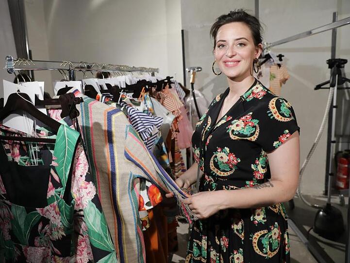 Designerin Lena Hoschek neben ihren Kleidern auf der Fashion Week 2018.