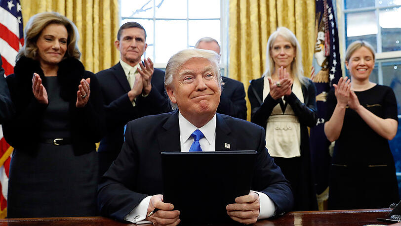 Präsident Donald Trump lächelt nach der Unterzeichung von drei Exekutiv Aktionen im Oval Office vom Weißen Haus.