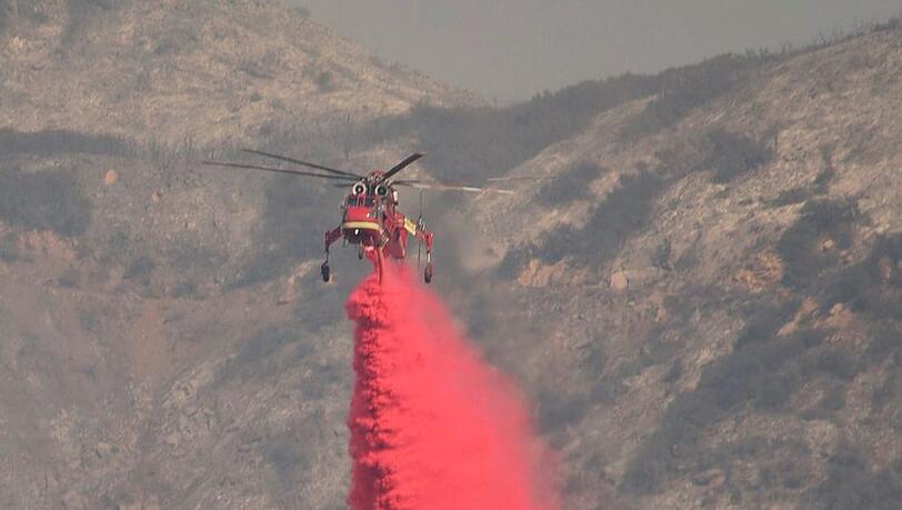 Ein Hubschrauber vom Typ Sikorsky S-64 Skycrane wirft Löschmittel über einem Buschfeuer in Santa Barbara ab. Ein Hubschrauber vom Typ Sikorsky S-64 Skycrane wirft Löschmittel über einem Buschfeuer in Santa Barbara ab.