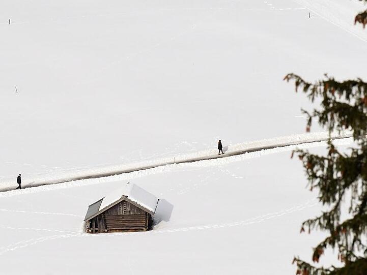 Das Bild zeigt das Winterwetter in Garmisch-Partenkirchen. Zwei Fußgänger laufen im Schnee. Foto: Angelika Warmuth