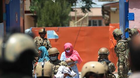 Sicherheitskräfte und Gesundheitspersonal mit Schutzmasken tragen Babys aus einem Krankenhaus nach einem Anschlag in Kabul.