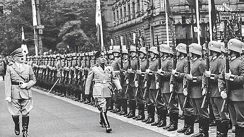 Hitler (l.) und Mussolini schreiten in München im September 1937 eine Formation deutscher Soldaten ab.