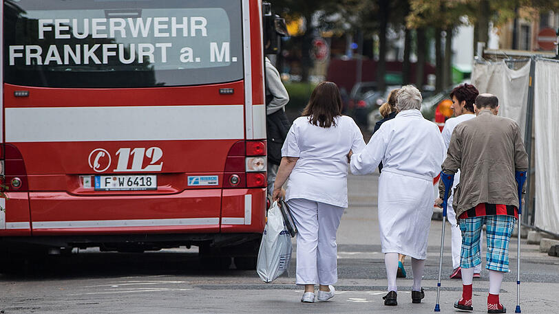 Patienten des Bürgerhospitals werden in Frankfurt am Main in einen Groß-Krankentransportwagen (GKTW) begleitet, um in ein anderes Krankenhaus verlegt zu werden, da die Klinik wegen einer Bombenentschärfung am Sonntag evakuiert werden muss.