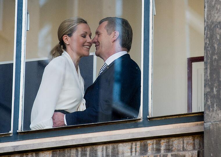 Küsschen links und rechts, eine sanfte Berührung: Christian Wulff hat Bettina Wulff vor dem Prozess in Hannover begrüßt. Medienwirksam vor einem Fenster.