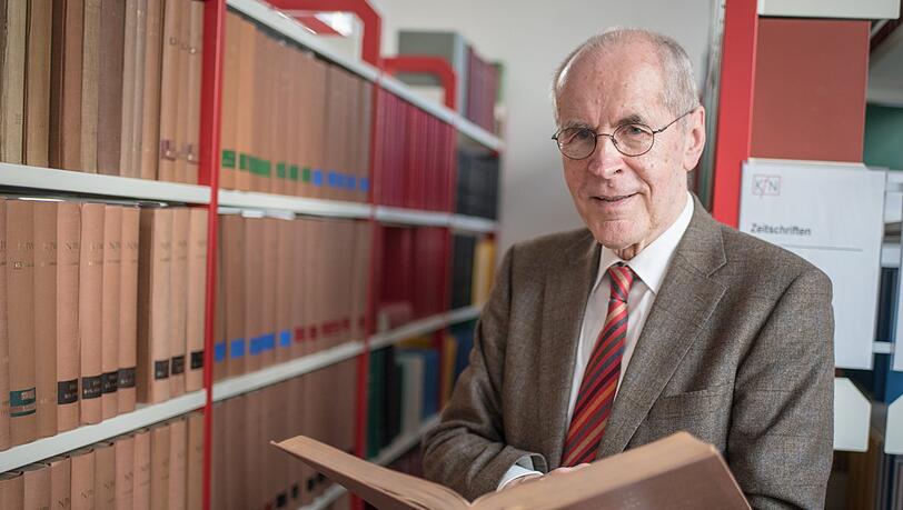 Der Kriminologe Christian Pfeiffer steht vor einer Bücherwand.