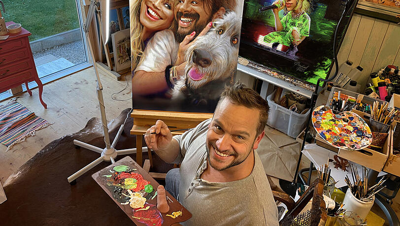 Bernhard Prinz vor der Karikatur von Heidi Klum und Tom Kaulitz.