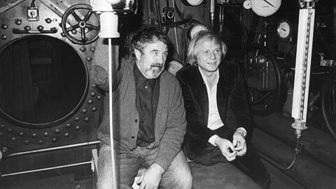 Wolfgang Petersen (r.) und der Schriftsteller Lothar-Günther Buchheim sitzen in dem original nachgebauten U-Boot für den Film "Das Boot" in den Bavaria-Filmstudios.