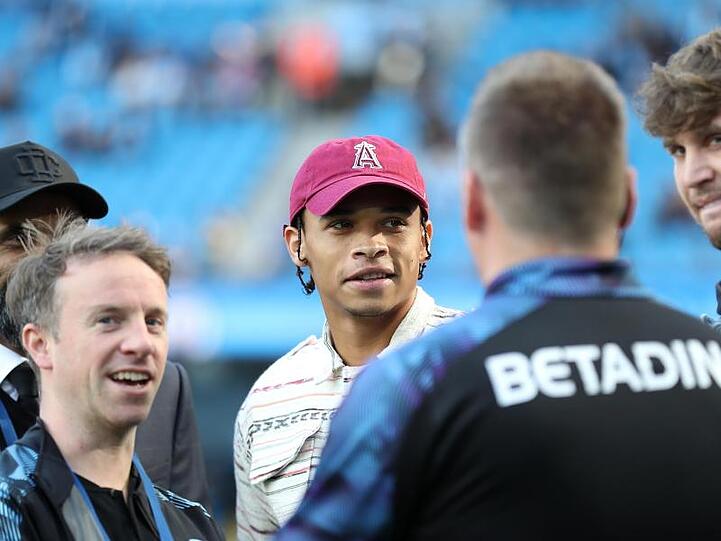 Manchester Citys verletzter Leroy Sané (M) steht am Spielfeldrand. Foto: Martin Rickett/PA Wire