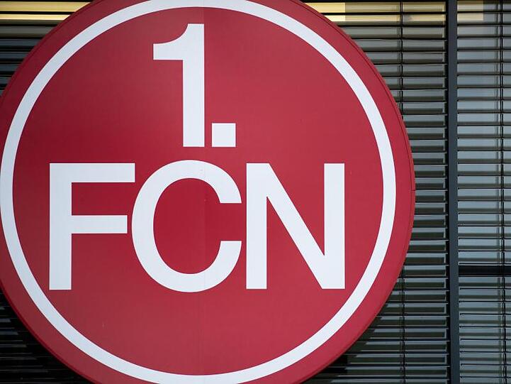 Das Logo des 1. FC Nürnberg hängt am Vereinsgebäude. Foto: Daniel Karmann/dpa/Symbolbild