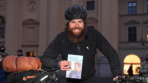 Der deutsche Extremsportler Jonas Deichmann präsentiert sein Fahrrad und sein Buch.
