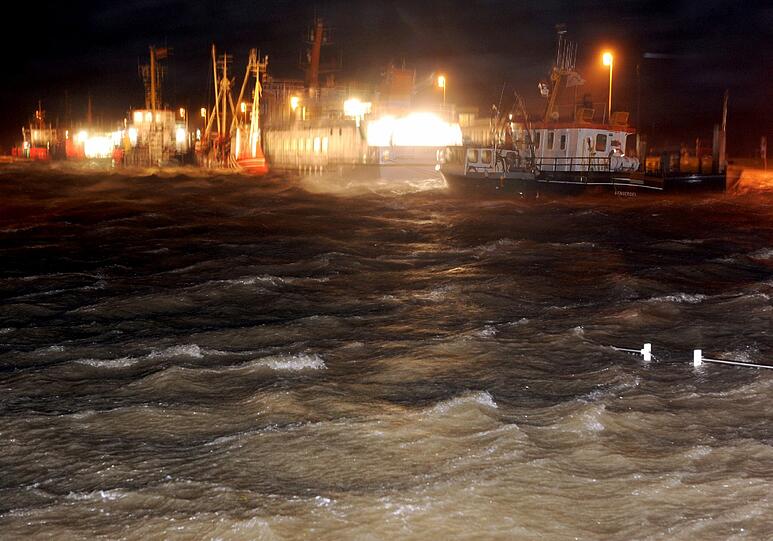 Schiffe an der Pier im Hafen von Bensersiel (Niedersachsen) tanzen am frühen Morgen des 06.12.2013 auf den sturmgepeitschen Wellen.